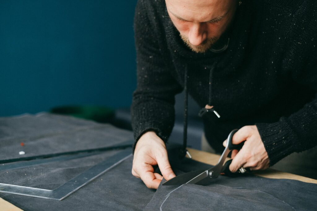 Tips for buying a leather jacket — expert craftsman cutting full-grain leather in India